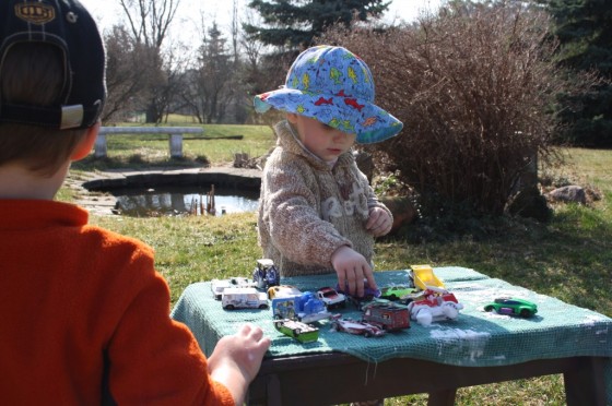 toddler drying car on table with tea towel