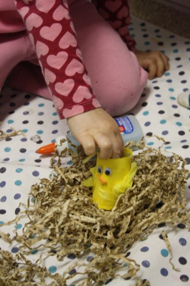 preschooler putting toilet roll chick in paper nest