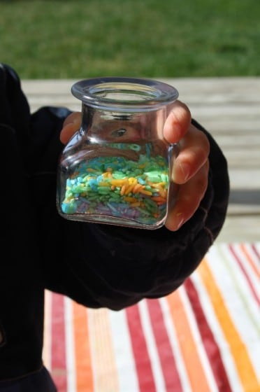 preschooler holding har of colourful rice