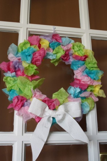 Easter wreath made with tissue paper hanging on a door.