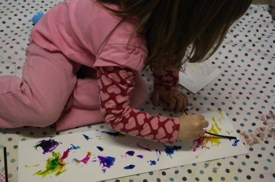 Kids pouring paint to prepare for their marbleized Easter craft.