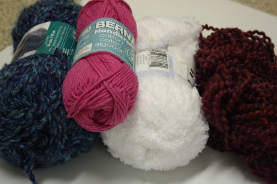 balls of yarn blue, pink, white, maroon