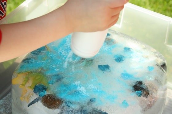 sprinkling blue salt on a block of ice