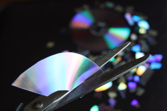 scissors cutting through cd or dvd