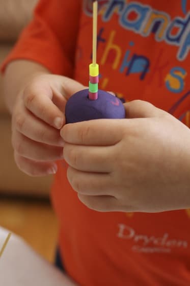 toddler playdough activity with beads and spaghetti