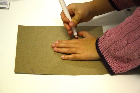 preschooler tracing her hand for cardboard