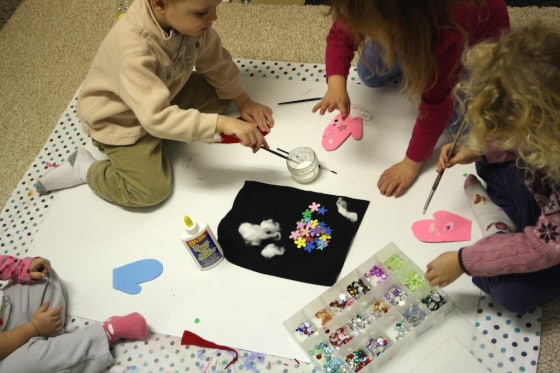 toddlers and preschoolers gluing craft gems to felt mittens