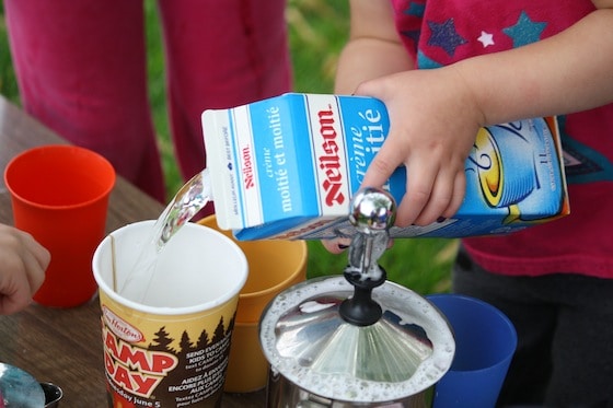 preschooler using cream carton filled with water for pretend play