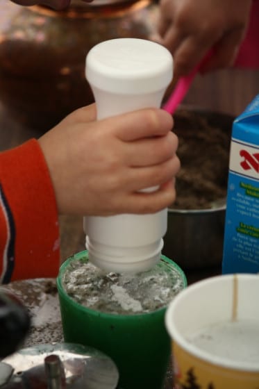 preschooler using shaker filled with sand