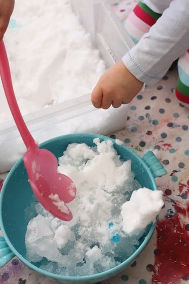 scooping snow into bowls of water