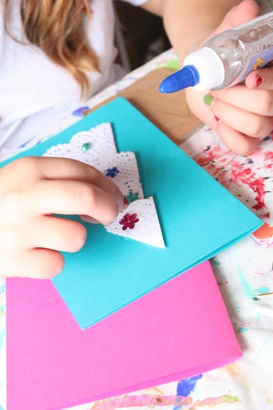 kid gluing doily tree