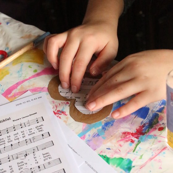 kid making cookie cutter sheet music ornament