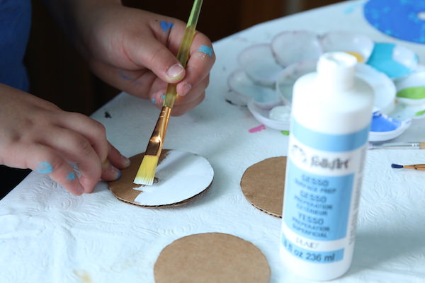 kid painting cardboard circle white