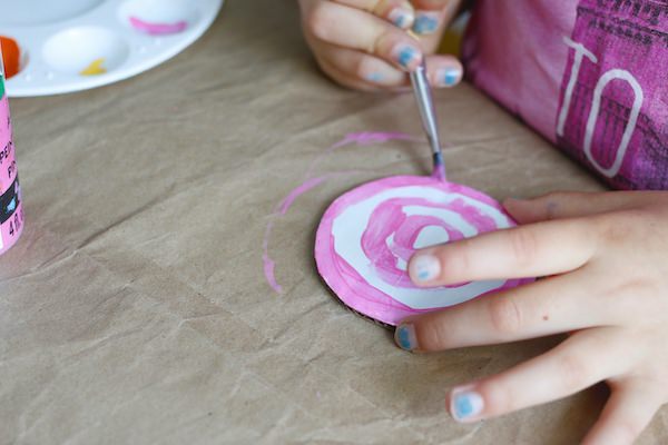 kid painting pink lollipop