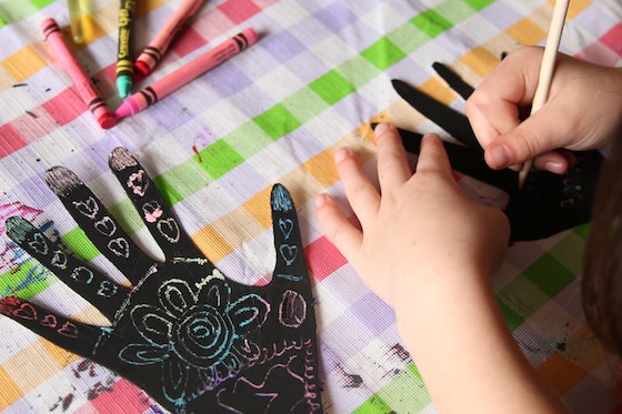 kids making henna hand art with scratch art process