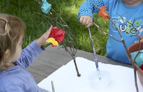 kids painting glue on twigs