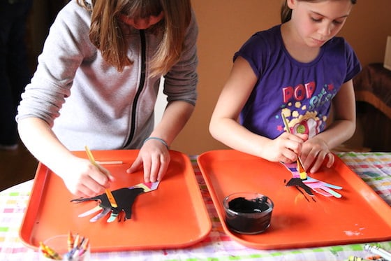 kids painting over coloured hands with black paint