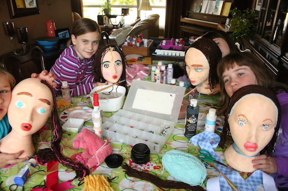 kids posing with styrofoam head self-portraits