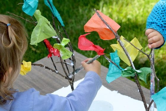 kids sticking tissue paper to twigs