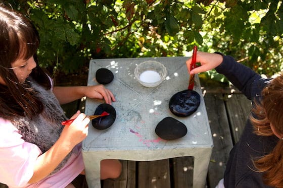 Kids varnishing black rocks