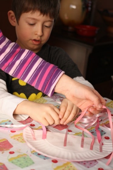 preschoolers taping legs on paper plate jelly fish