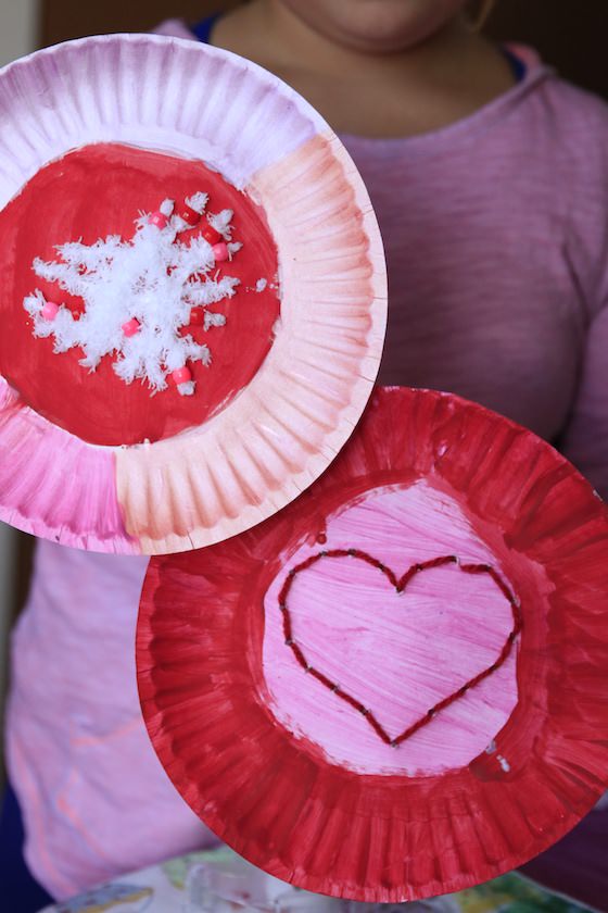 10 year old holding up 2 paper plates decorated for Valentines day