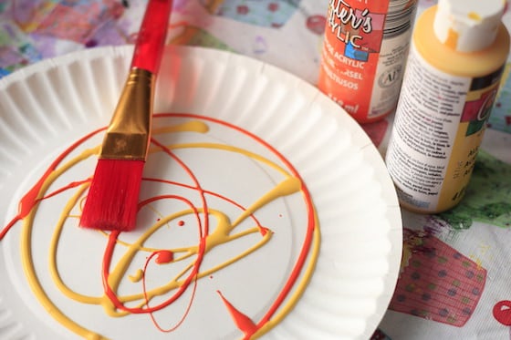 yellow and orange paint on paper plate