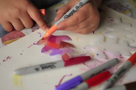 child colouring plastic fall leaf with a sharpie marker