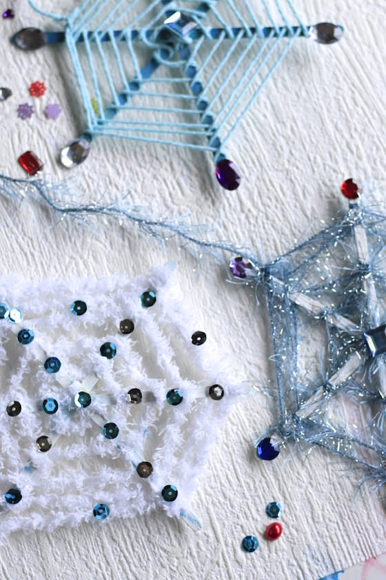 3 snowflake ornaments with yarn and craftsticks