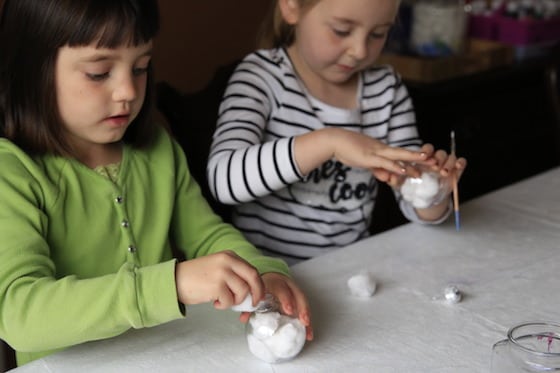 2 girls stuffing ornaments with cotton balls