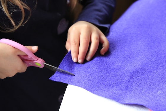 Child cutting purple felt