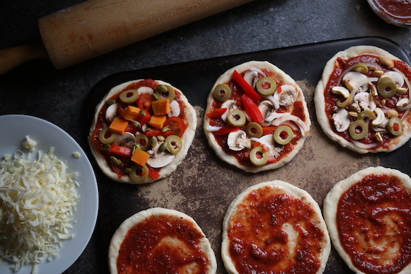 6 homemade mini pizzas on baking stone