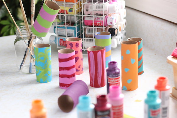 painted cardboard rolls with stripes painted on