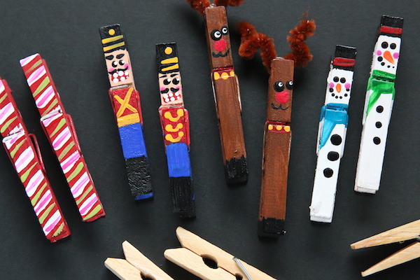 painted clothespin ornaments on black background with unpainted wooden clothespins