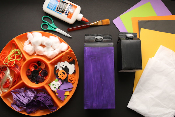 painted milk cartons, orange tray of buttons, halloween foam shapes, yarn, cotton balls 