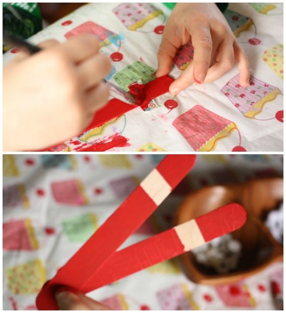 child painting craft sticks red