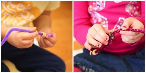 Threading cheerios and blueberries onto pipe cleaners