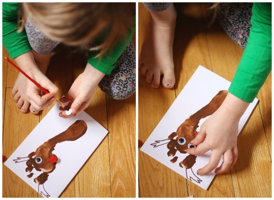 Child glueing googly eyes on reindeer footprint card