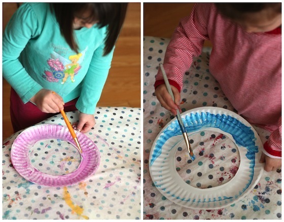 Painting paper plates to make an easter wreath.