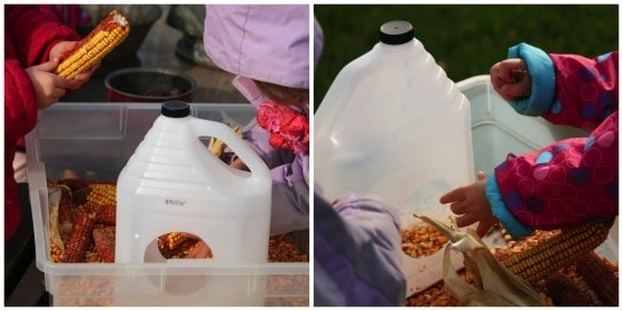 children filling milk jug bird feeder with corn kernels