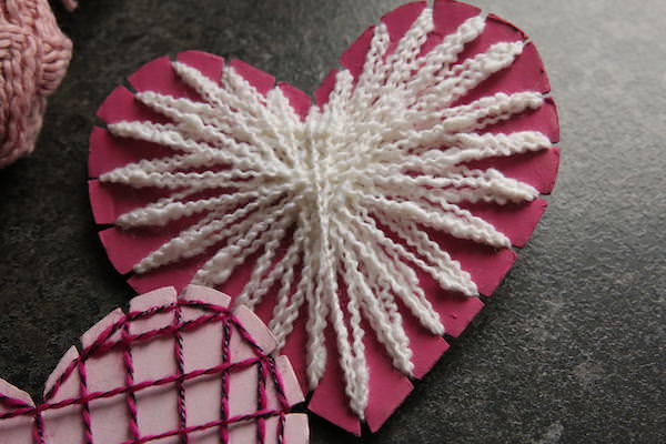 Pink cardboard heart with white string
