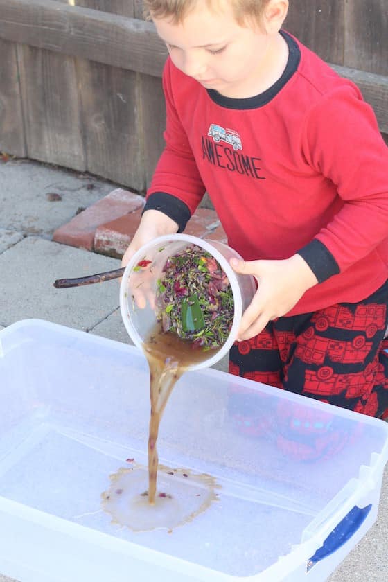 preschooler dumping water into shallow bin