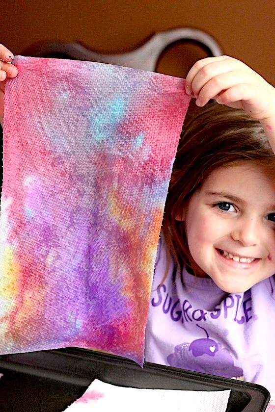 Preschooler holding up art project