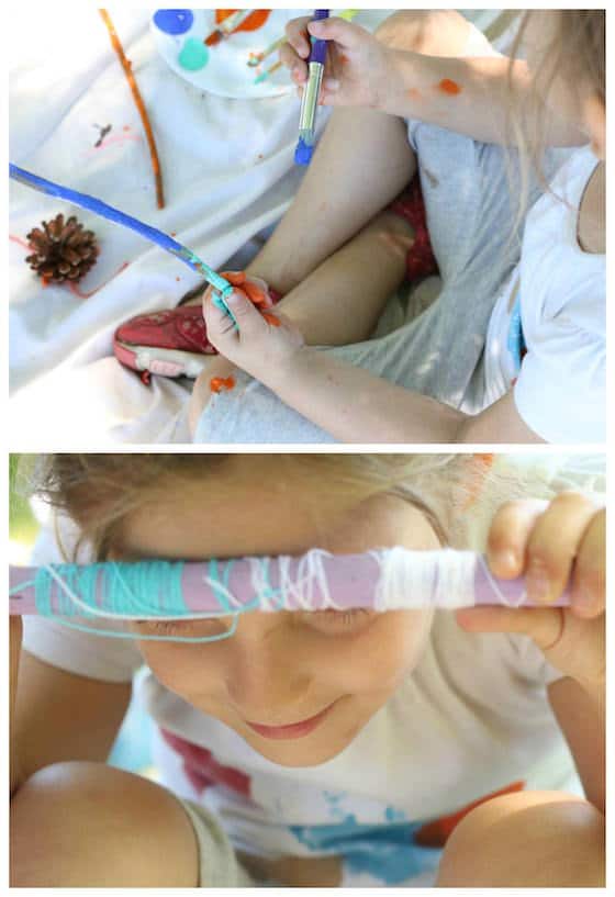 preschooler painting stick blue and wrapping with yarn