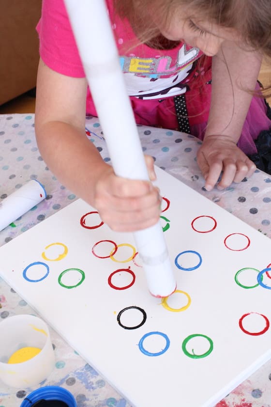 preschooler stamping Olympic Rings on canvas