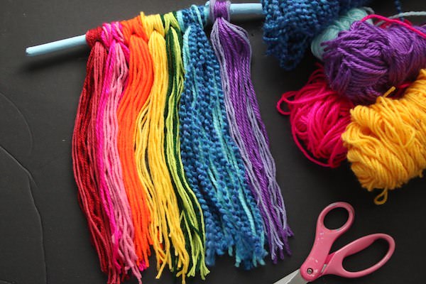 Rainbow coloured yarn tied to stick