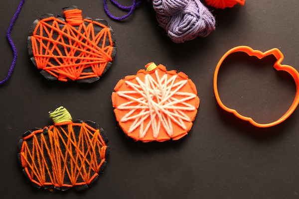 3 yarn wrapped pumpkins, balls of yarn and pumpkin cookie cutter 