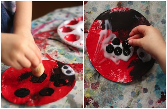 stamping black spots with a cork on red paper plate