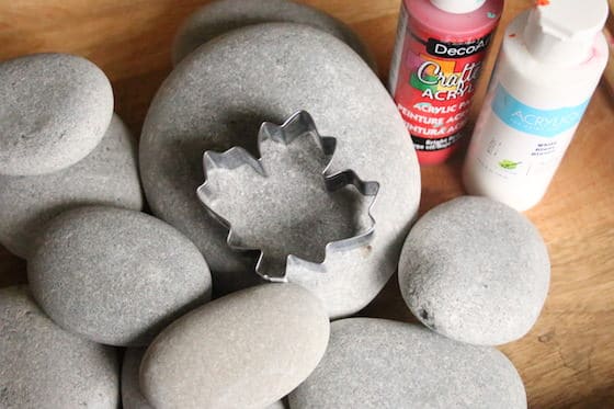 Smooth beach rocks, maple leaf cookie cutter, red and white paint