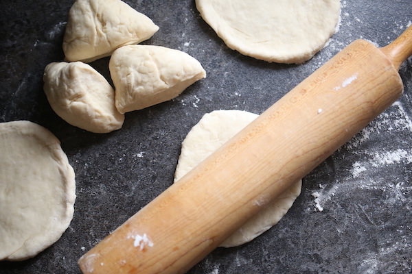 Rolling pin, dough and mini pizza crusts